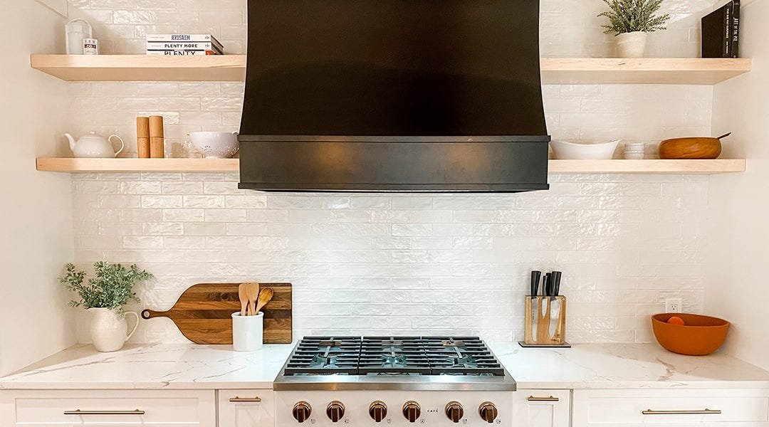 Kitchen with a sloped style wood range hood