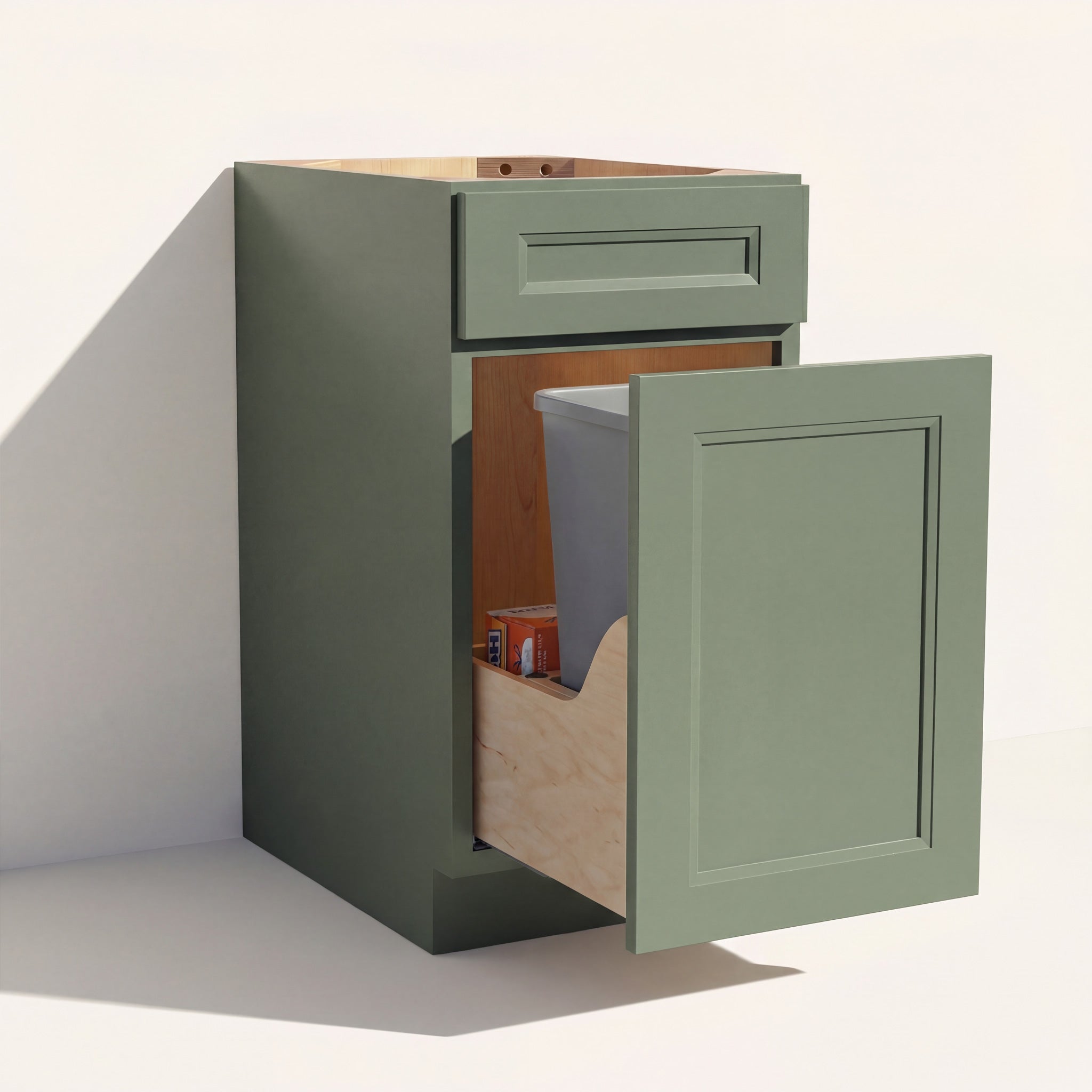 Angled view of a green Belmont beveled Shaker trash pull-out base cabinet with 1 bin and 1 functional drawer.