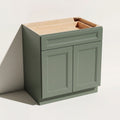 Angled view of a green Belmont beveled Shaker standard double door base cabinet with 2 doors and 1 functional drawer.