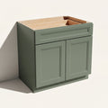 Angled view of a green 33w Belmont beveled Shaker standard base cabinet with 2 doors and 1 functional drawer.