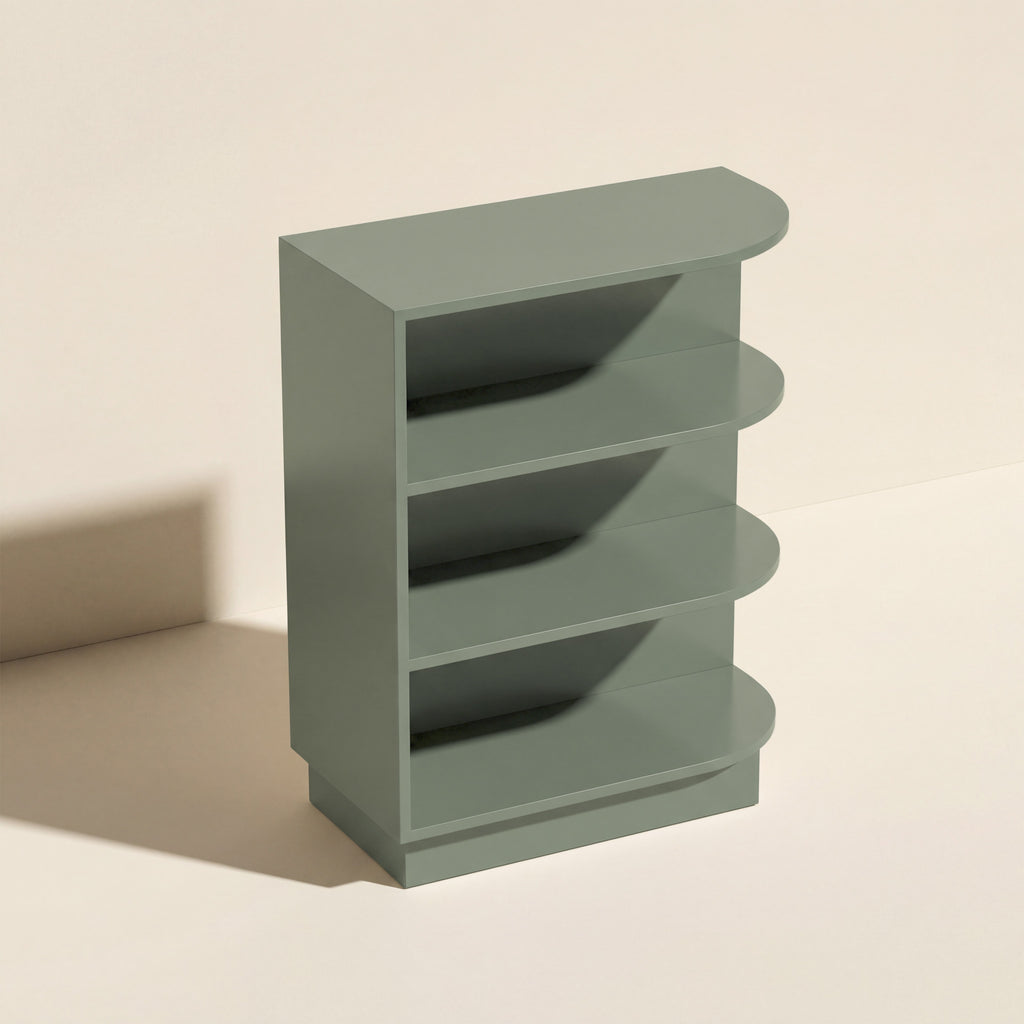 Angled view of a green Belmont beveled Shaker open end base cabinet with three shelves.