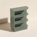 Angled view of a green Belmont beveled Shaker open end base cabinet with three shelves.
