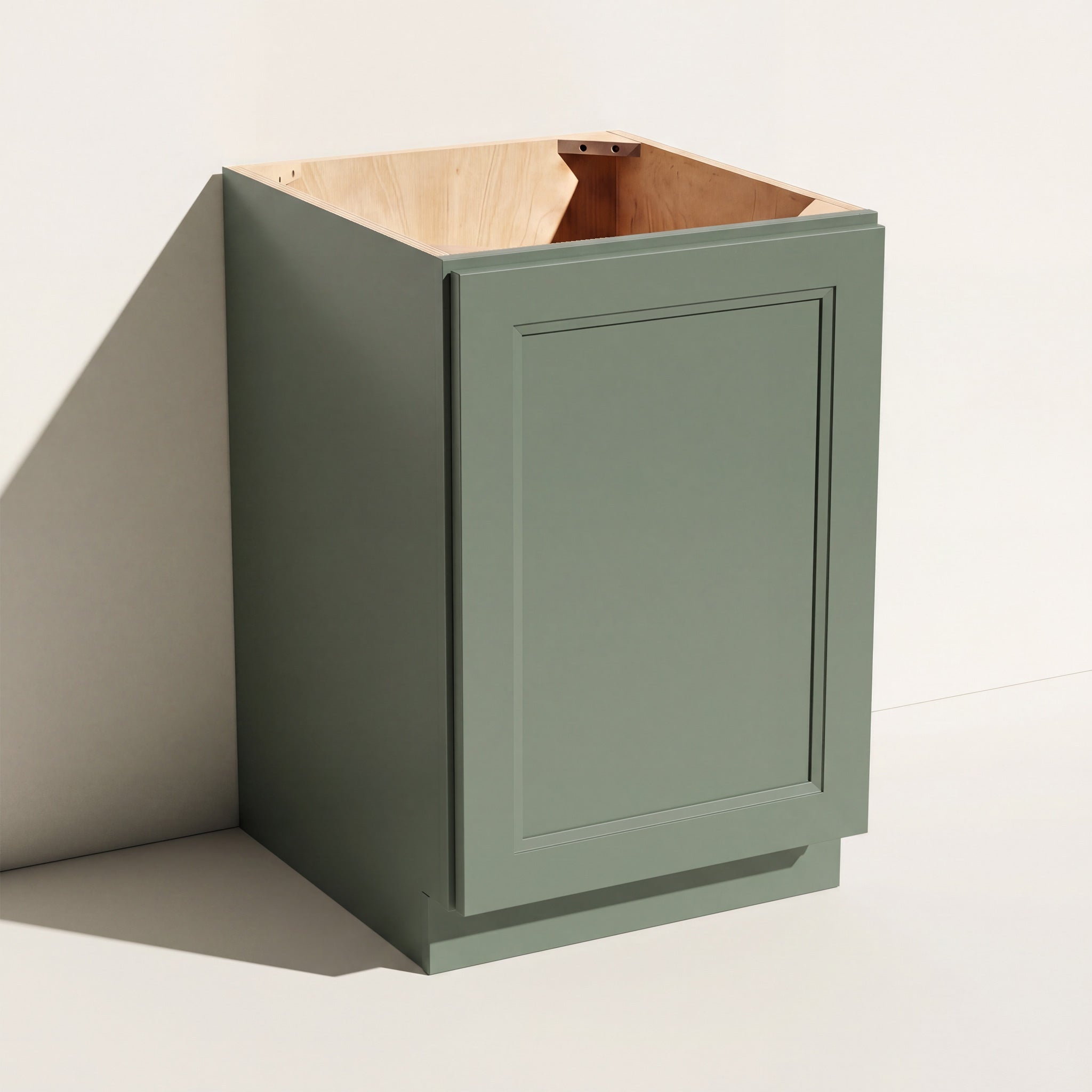 Angled view of a green Belmont beveled Shaker full height base cabinet with 1 door and 1 shelf.