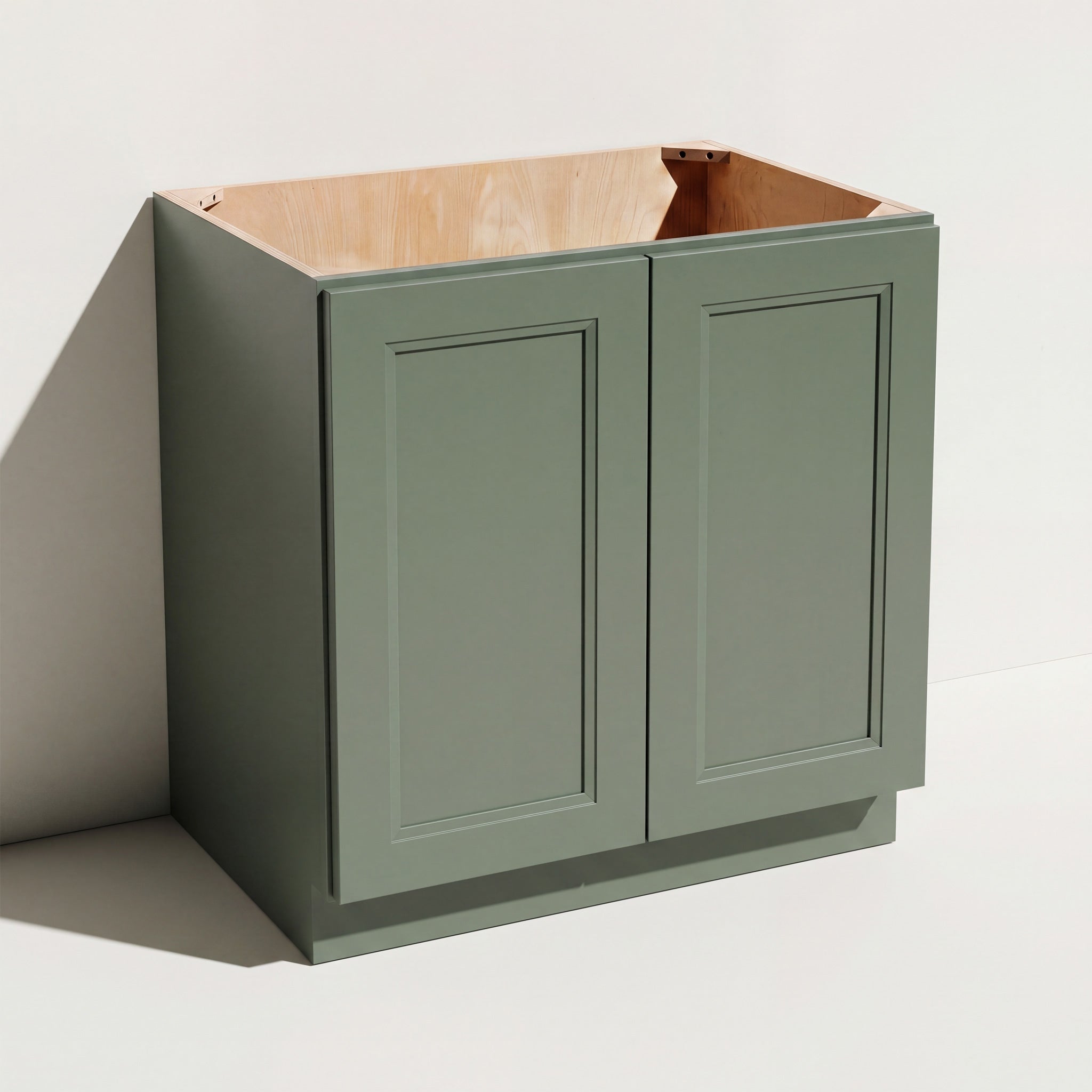 Angled view of a green Belmont beveled Shaker full height double door base cabinet with 2 doors.