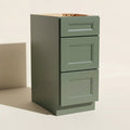 Angled view of a green Belmont beveled Shaker 3-drawer base cabinet.