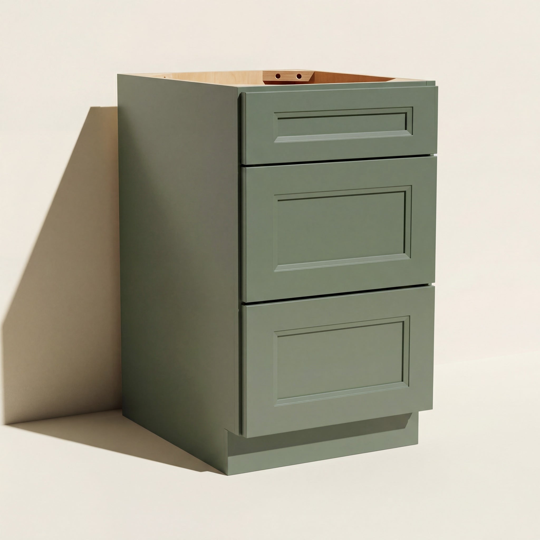 Angled view of a green 18w Belmont beveled mid-width Shaker 3-drawer base cabinet.