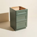 Angled view of an assembled green Belmont beveled Shaker 3-drawer base cabinet.