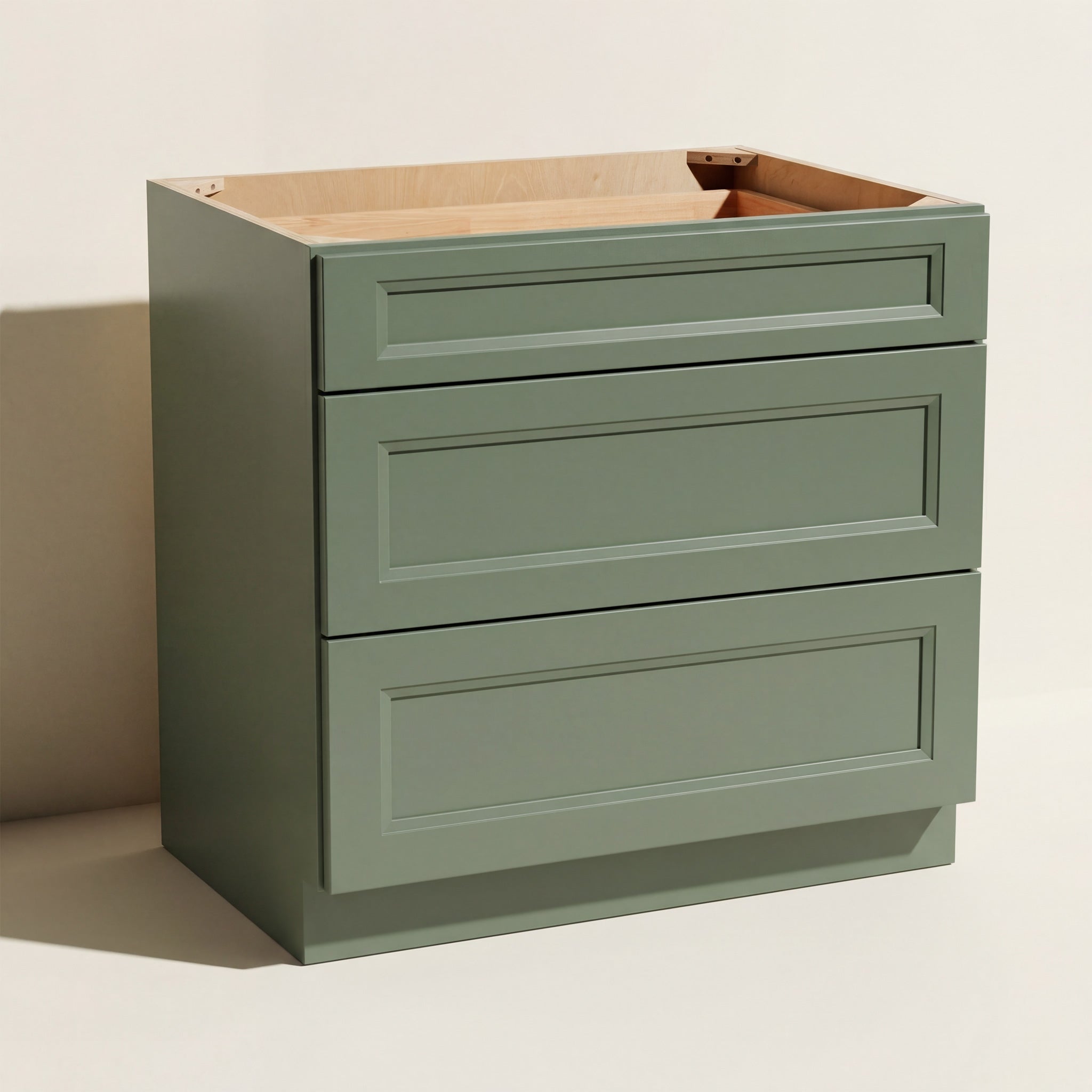 Angled view of a green Belmont beveled Shaker standard base cabinet with 3 drawers.