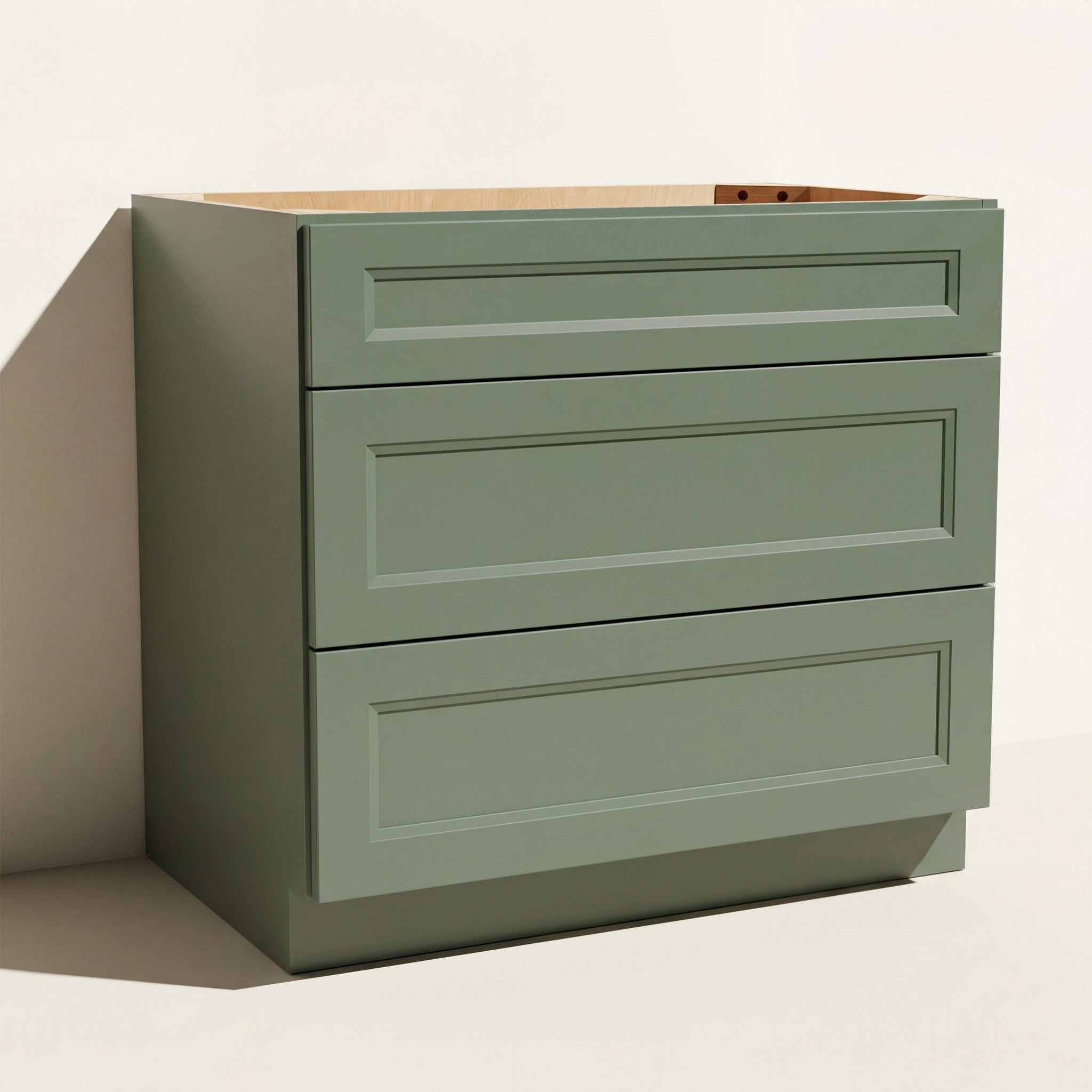Angled view of a green 36w Belmont beveled Shaker drawer base cabinet with 3 functional drawers.