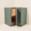Angled view of a green Belmont beveled Shaker easy reach corner base cabinet with 1 bi-fold door.