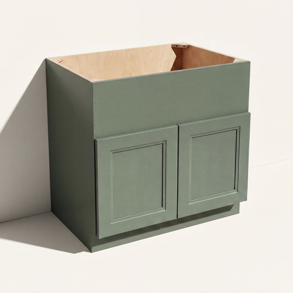 Angled view of a green 33w Belmont beveled Shaker farm sink base with 2 doors and panel to be cut to fit sink during install.