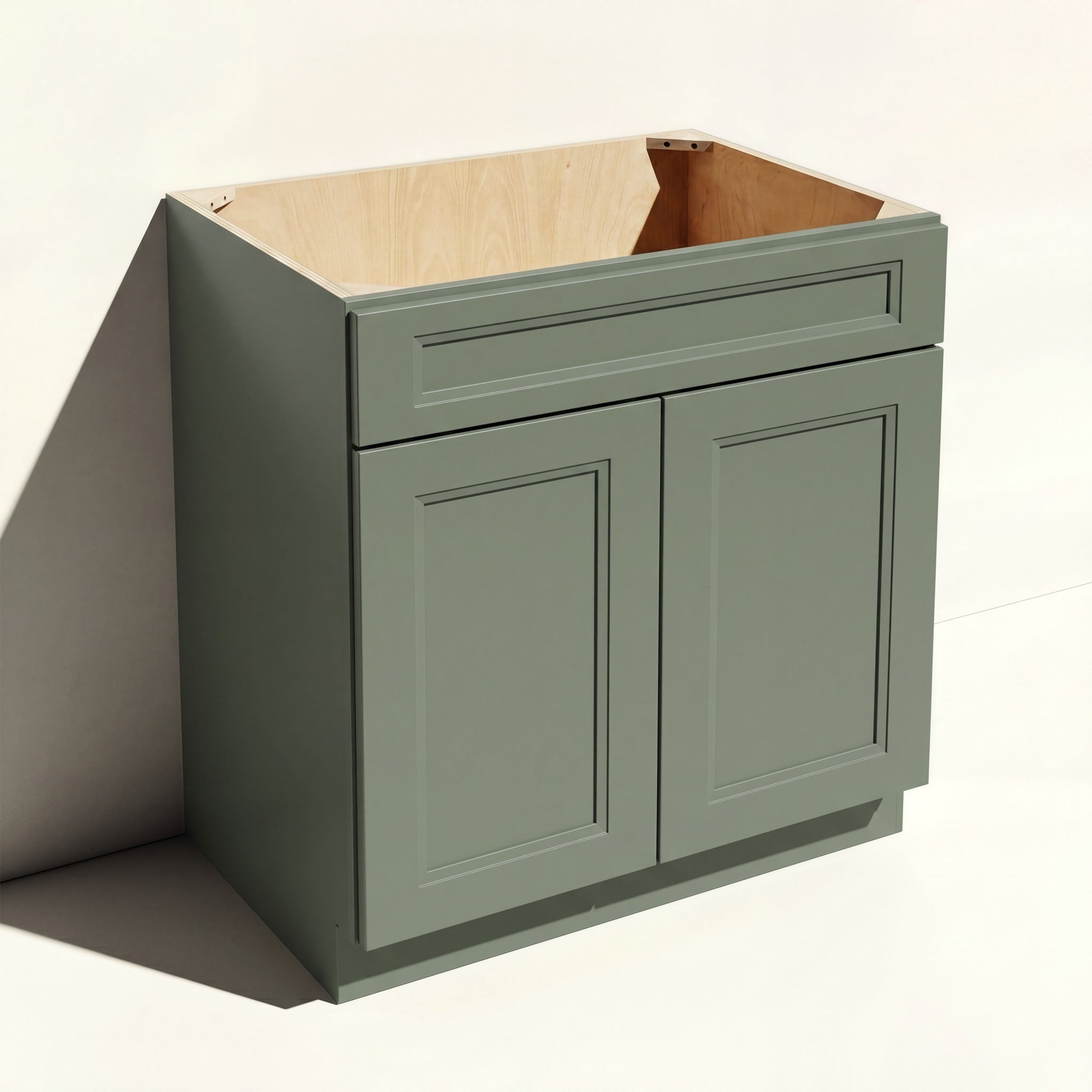 Angled view of a green Belmont beveled Shaker sink base cabinet with 2 doors and 1 false drawer front.