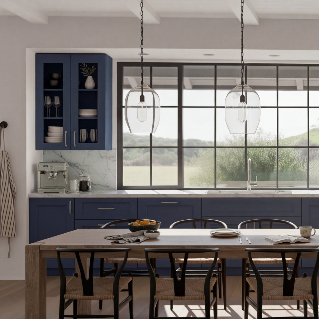 Belmont Blue trim, filler, & panels in modern kitchen with white marble countertops, large black-framed window, and pendant lighting.
