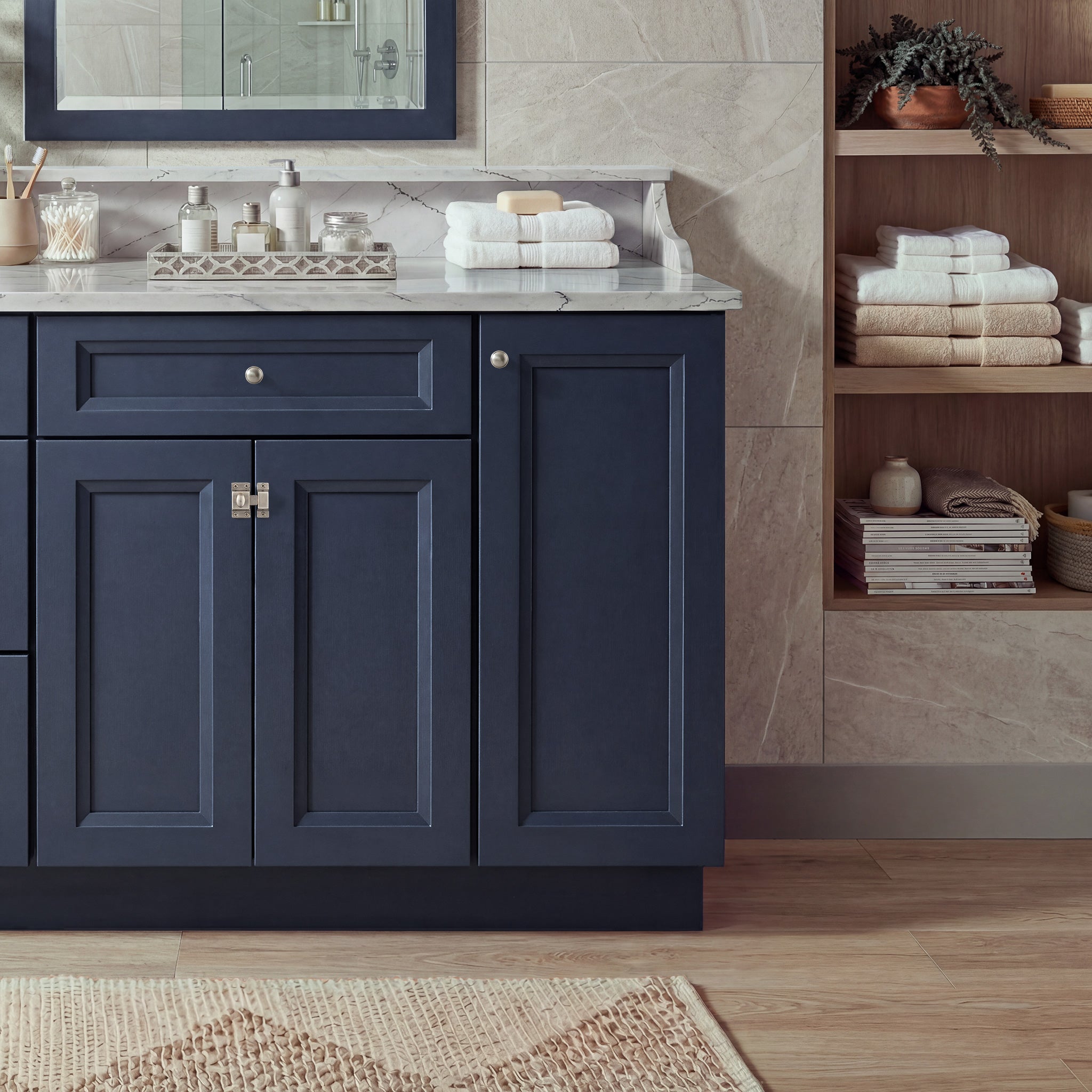 Front view of a blue Belmont contemporary vanity base cabinet with 3 doors and 1 drawer in a styled bathroom.