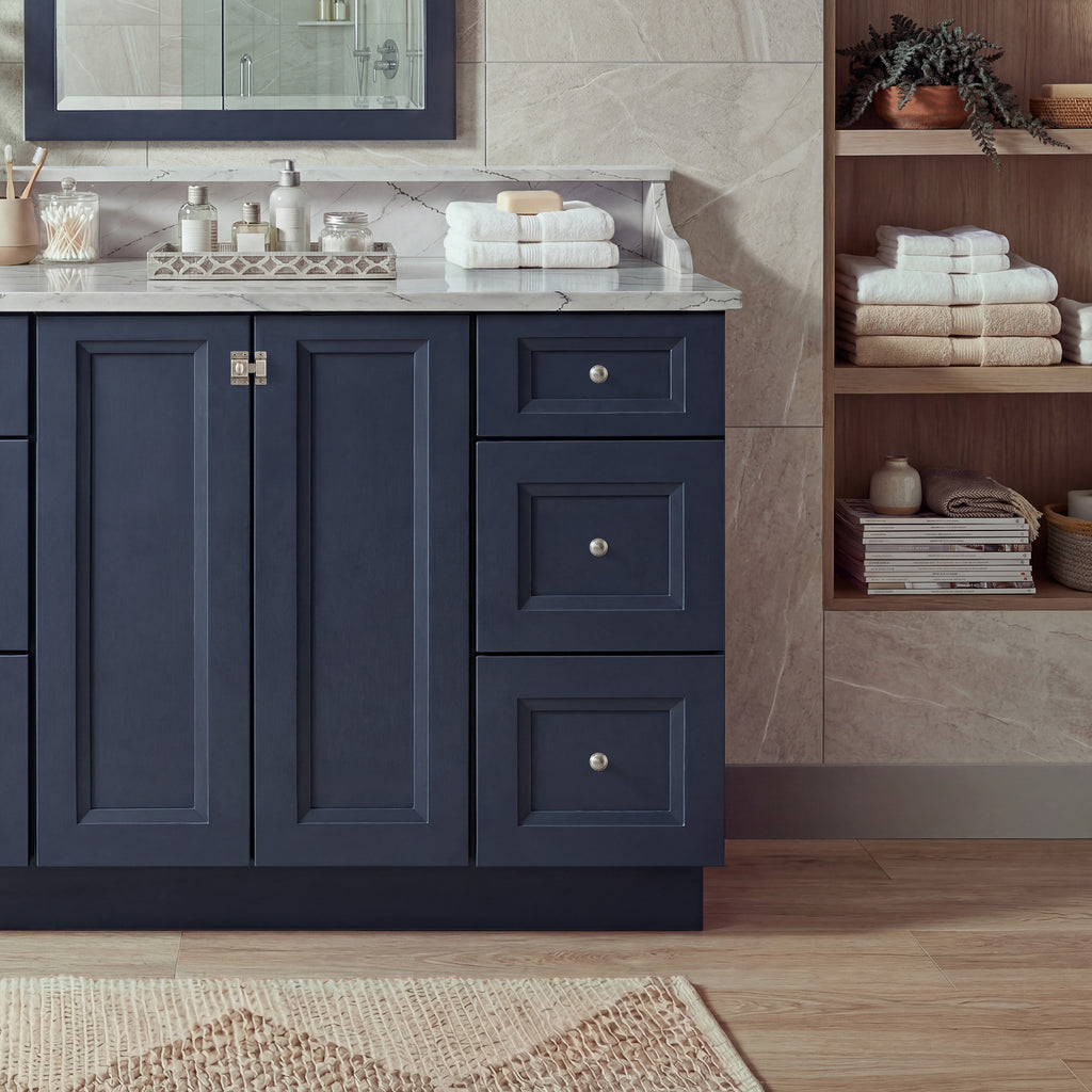 Front view of a blue Belmont contemporary vanity base cabinet with 2 full-height doors and 3 drawers in a styled bathroom.