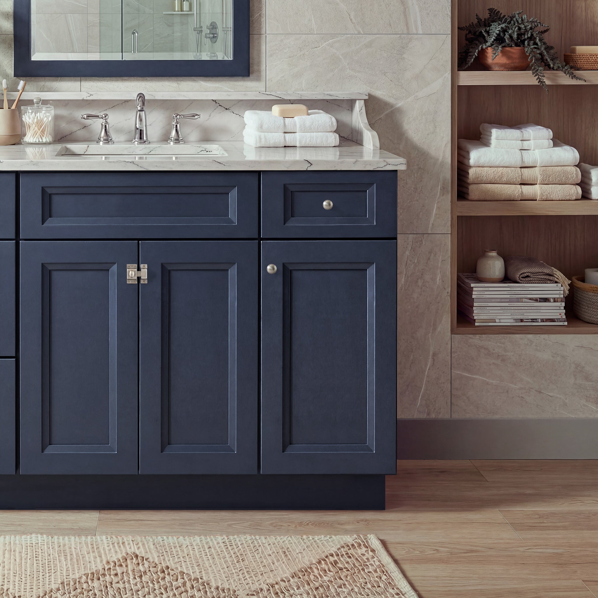Front view of a blue Belmont shaker vanity with 2 doors, 1 drawer, and 1 false front with a nickel latch in a warm bathroom.