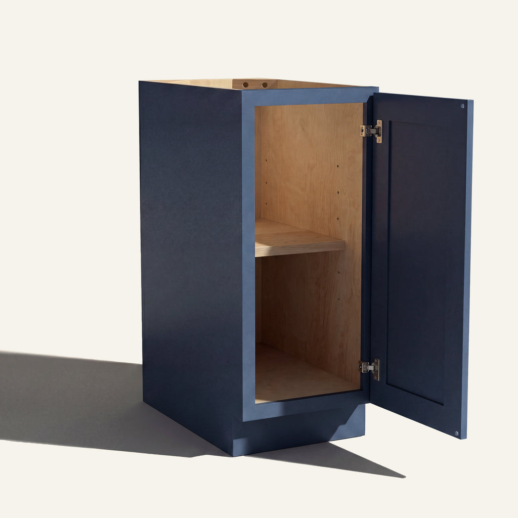 Angled view of a blue Belmont beveled Shaker base cabinet with 1 door open showing wood interior and shelf.