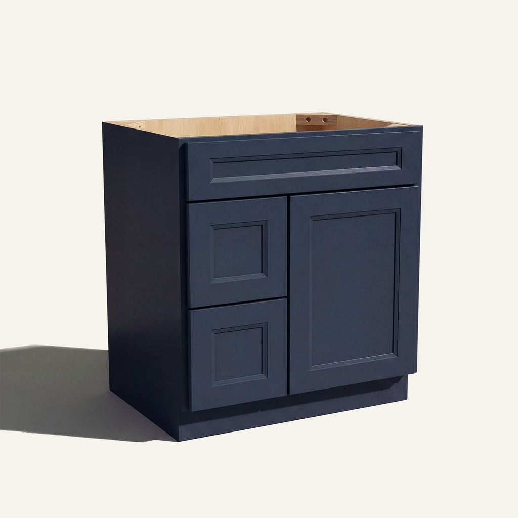 Angled view of a blue Belmont beveled shaker single sink vanity with a right-side door and two left-side drawers.
