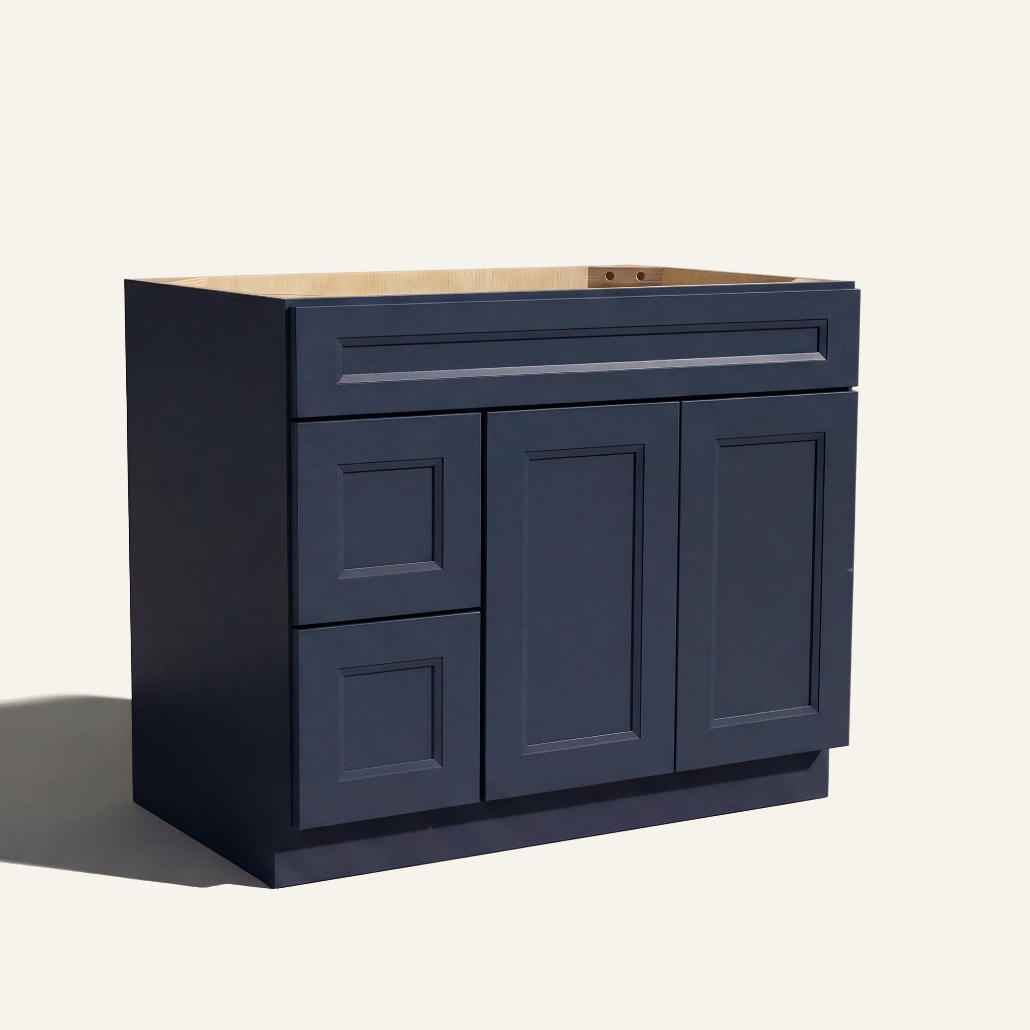 Angled view of a blue Belmont beveled shaker single sink vanity featuring two doors and a left-side drawer bank.