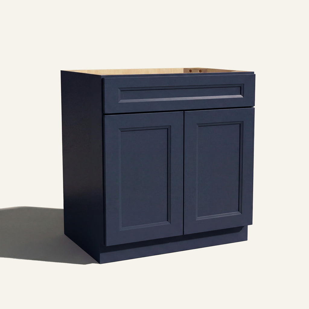 Angled view of a blue Belmont beveled Shaker vanity sink base with 2 doors and 1 false drawer front.
