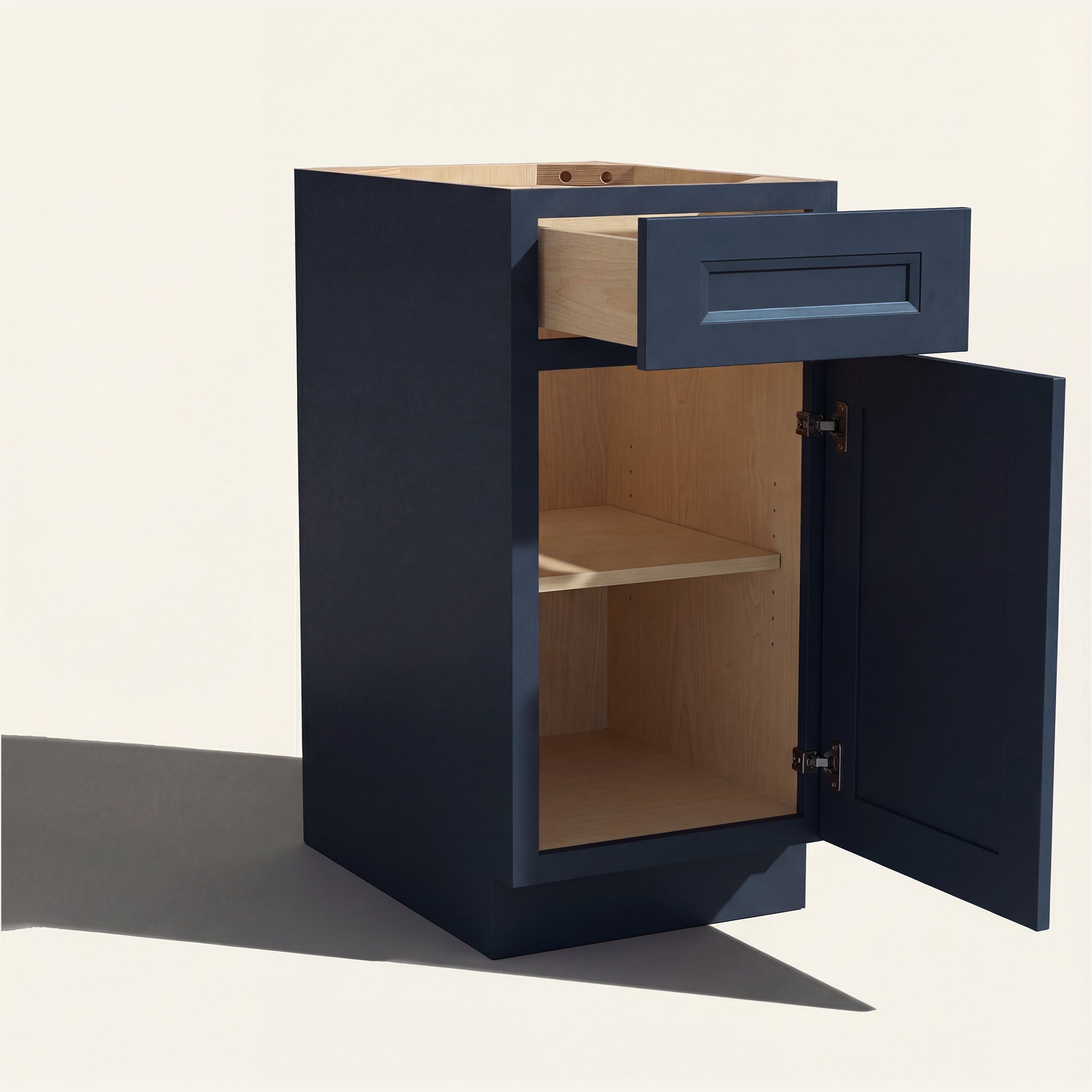 Angled view of a blue Belmont beveled Shaker vanity base cabinet with 1 door and 1 drawer open showing wood interior.