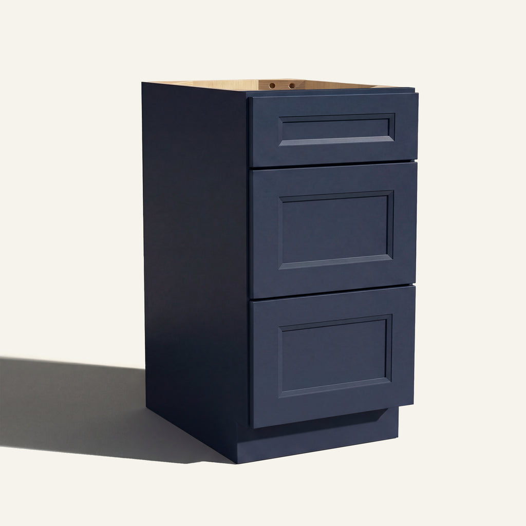 Angled view of a blue Belmont beveled Shaker vanity base with 3 drawers stacked.