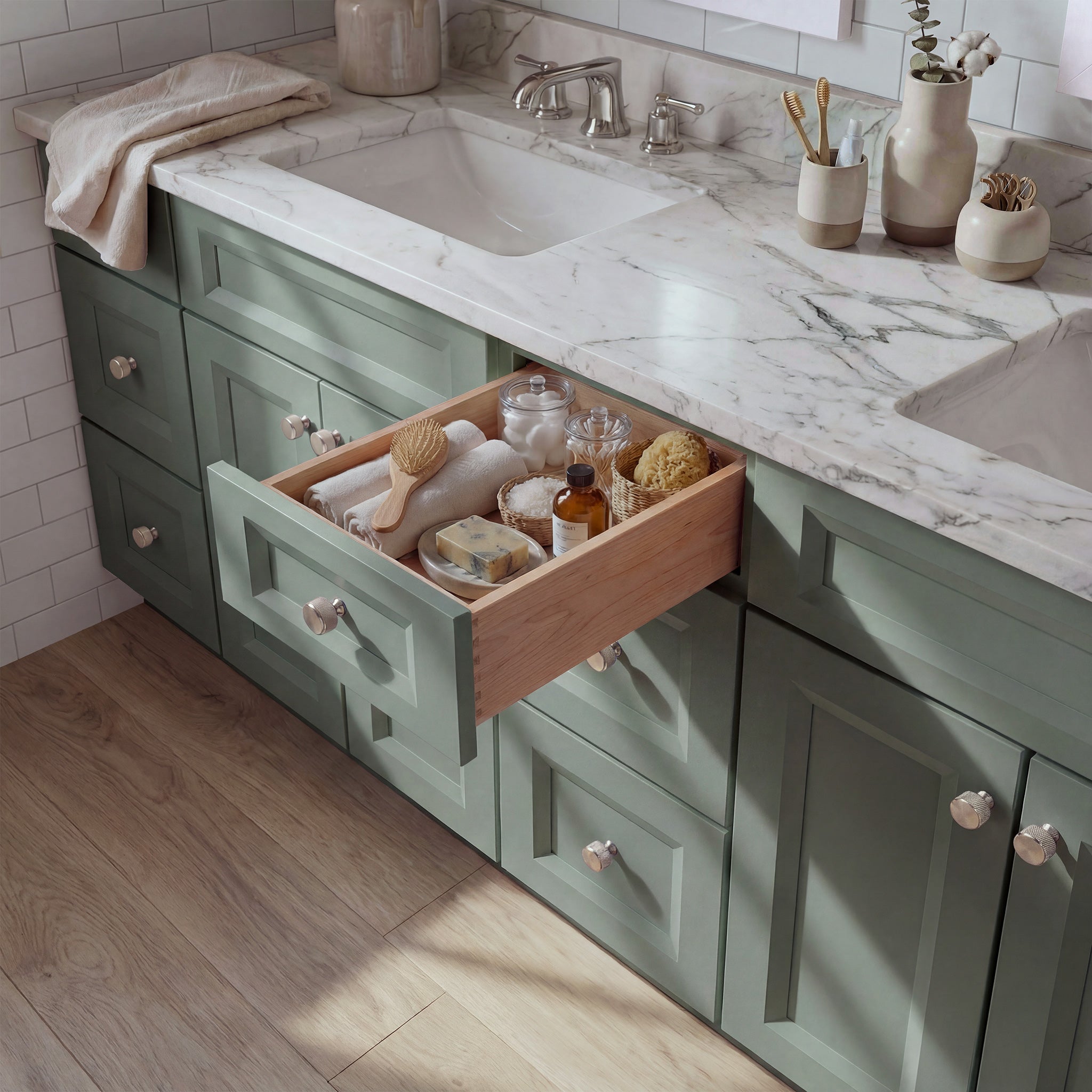 Top-down angled view of a green Belmont shaker vanity with an open drawer, lived-in feel, and Mont Blanc quartzite counter.