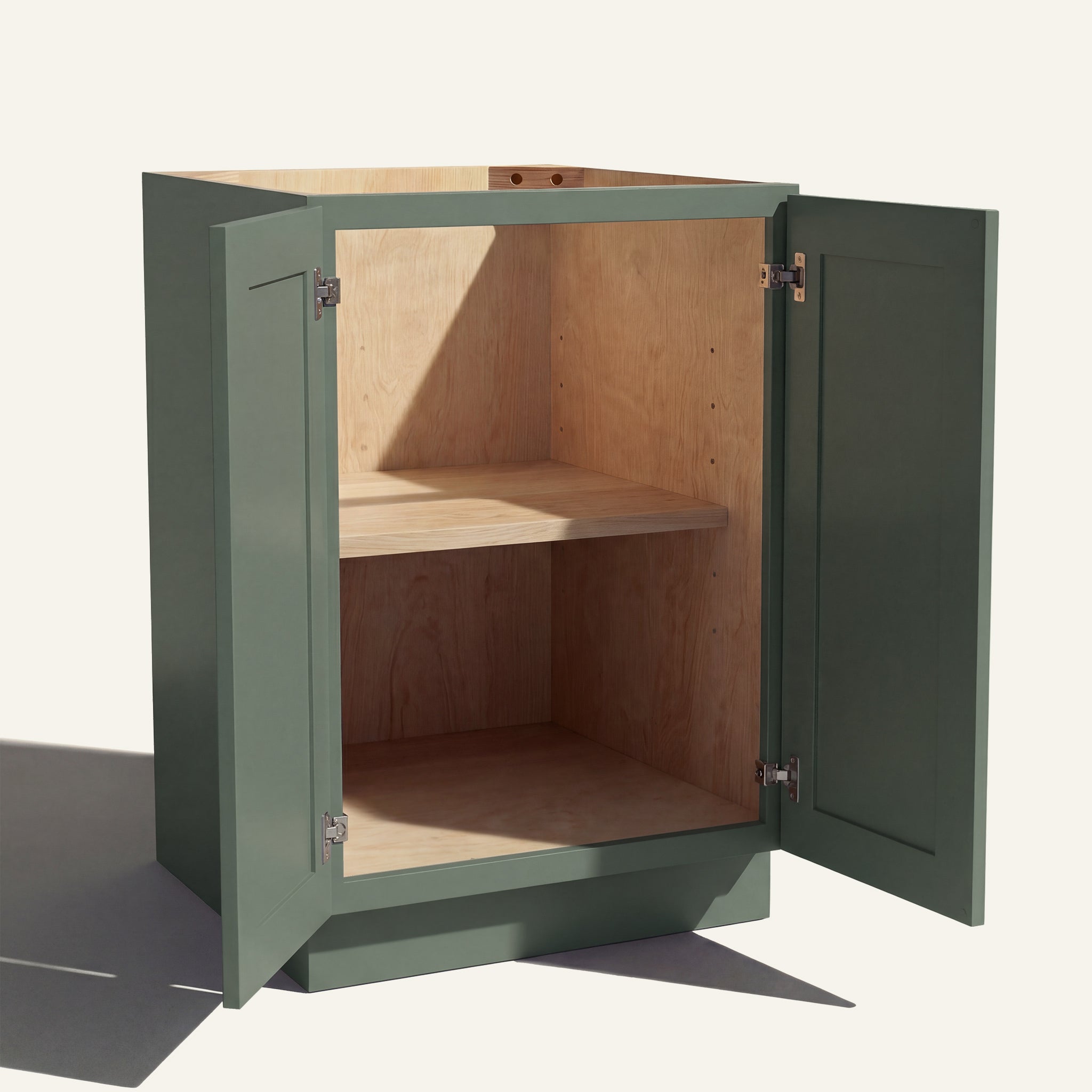 Angled view of a green Belmont beveled Shaker base cabinet with 2 full height doors open showing wood interior and shelf.