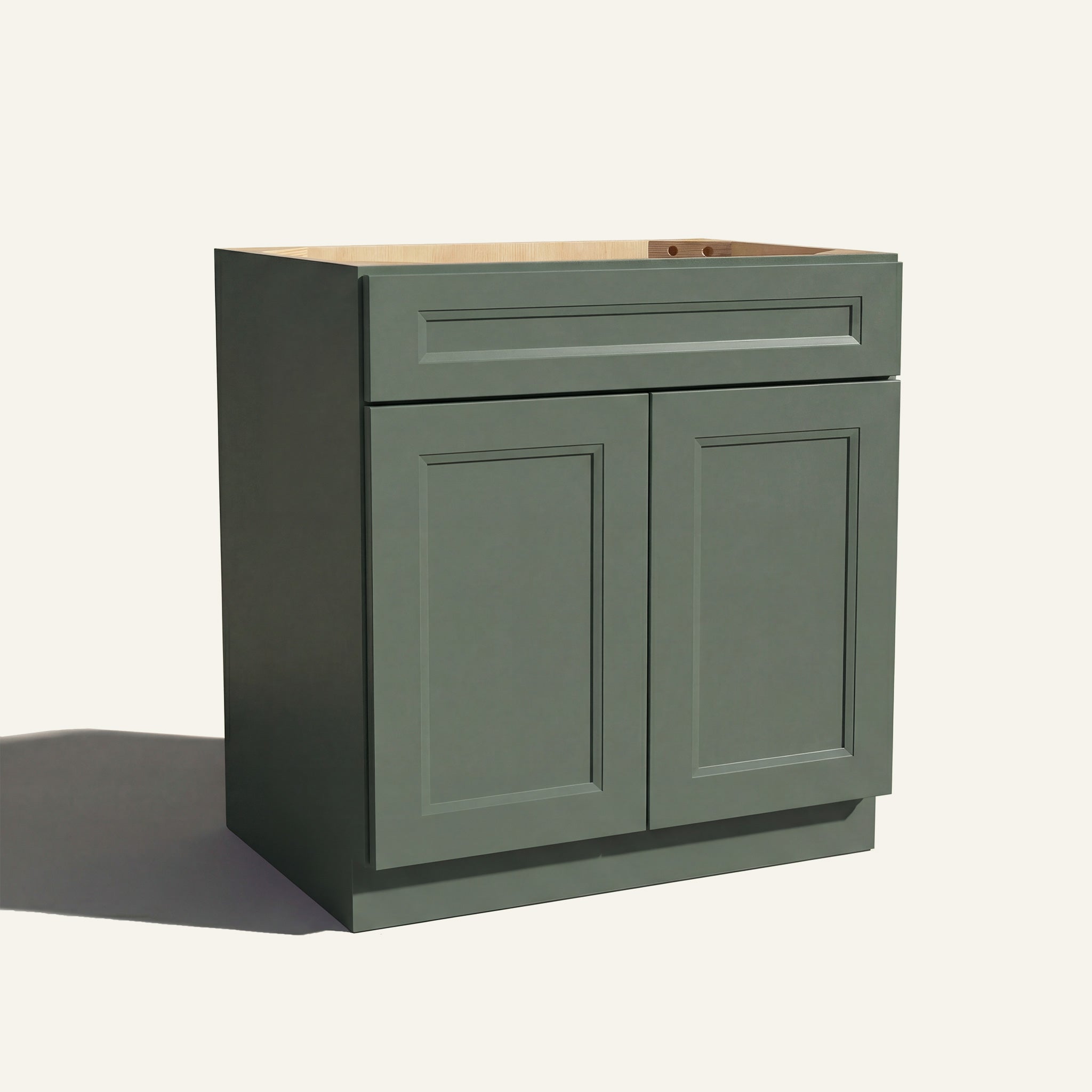 Angled view of a green Belmont beveled Shaker vanity sink base with 2 doors and 1 false drawer front.