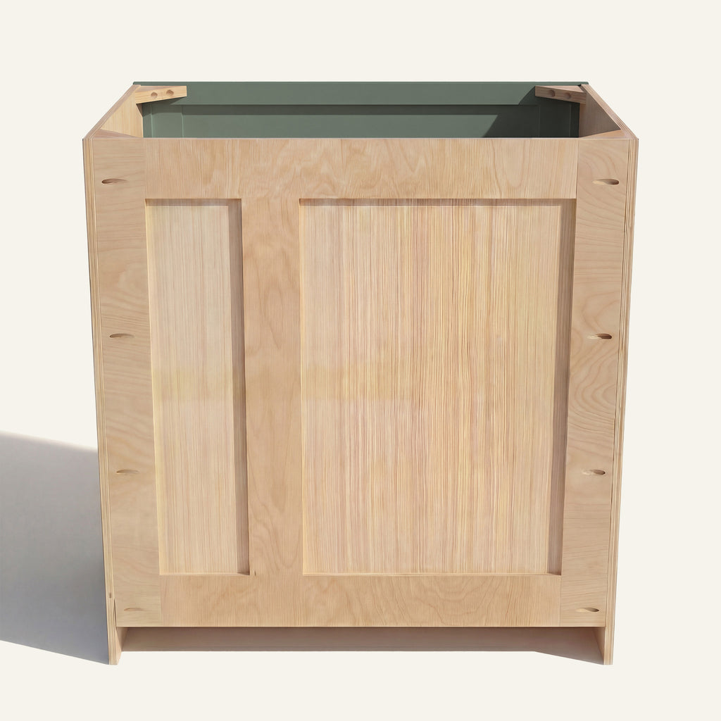 Rear view of a green Belmont vanity with offset plumbing supports, pocket screw holes, and builder grade plywood construction.