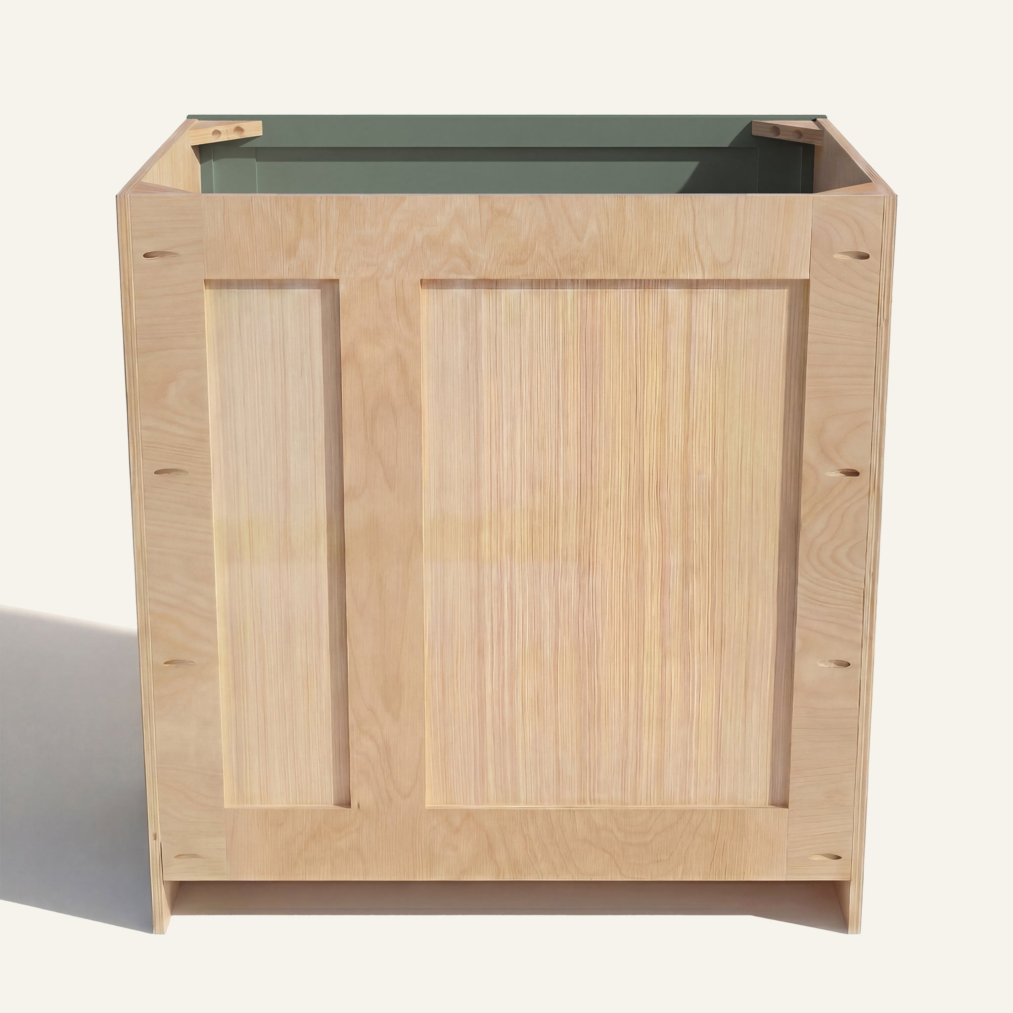 Rear view of a green Belmont vanity with offset plumbing supports, pocket screw holes, and builder grade plywood construction.