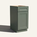 Angled view of a green Belmont beveled Shaker vanity base cabinet with 1 door and 1 drawer.