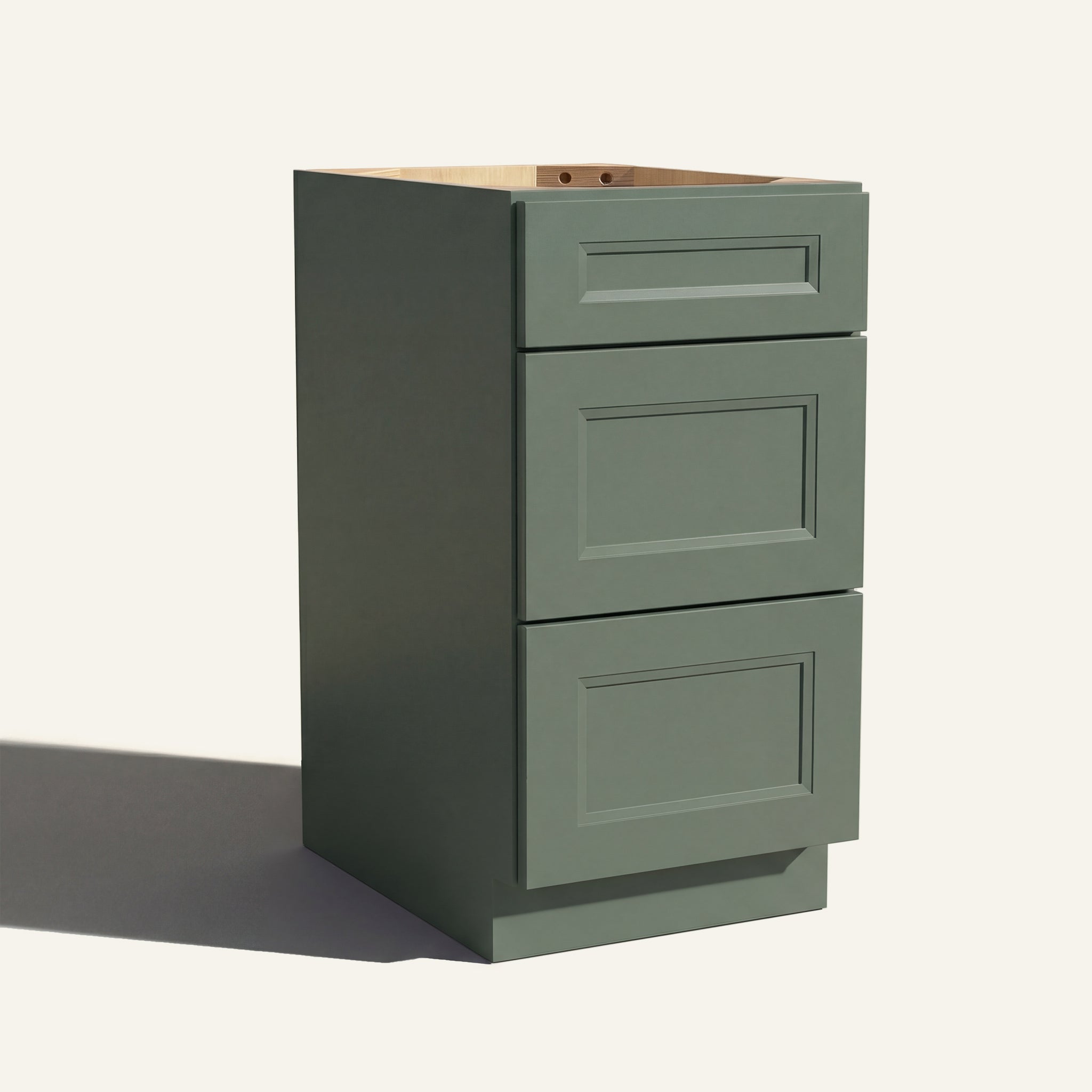 Angled view of a green Belmont beveled Shaker vanity base with 3 drawers stacked.