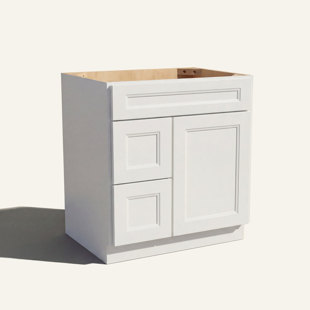 Angled view of a white Belmont beveled shaker single sink vanity with a right-side door and two left-side drawers.