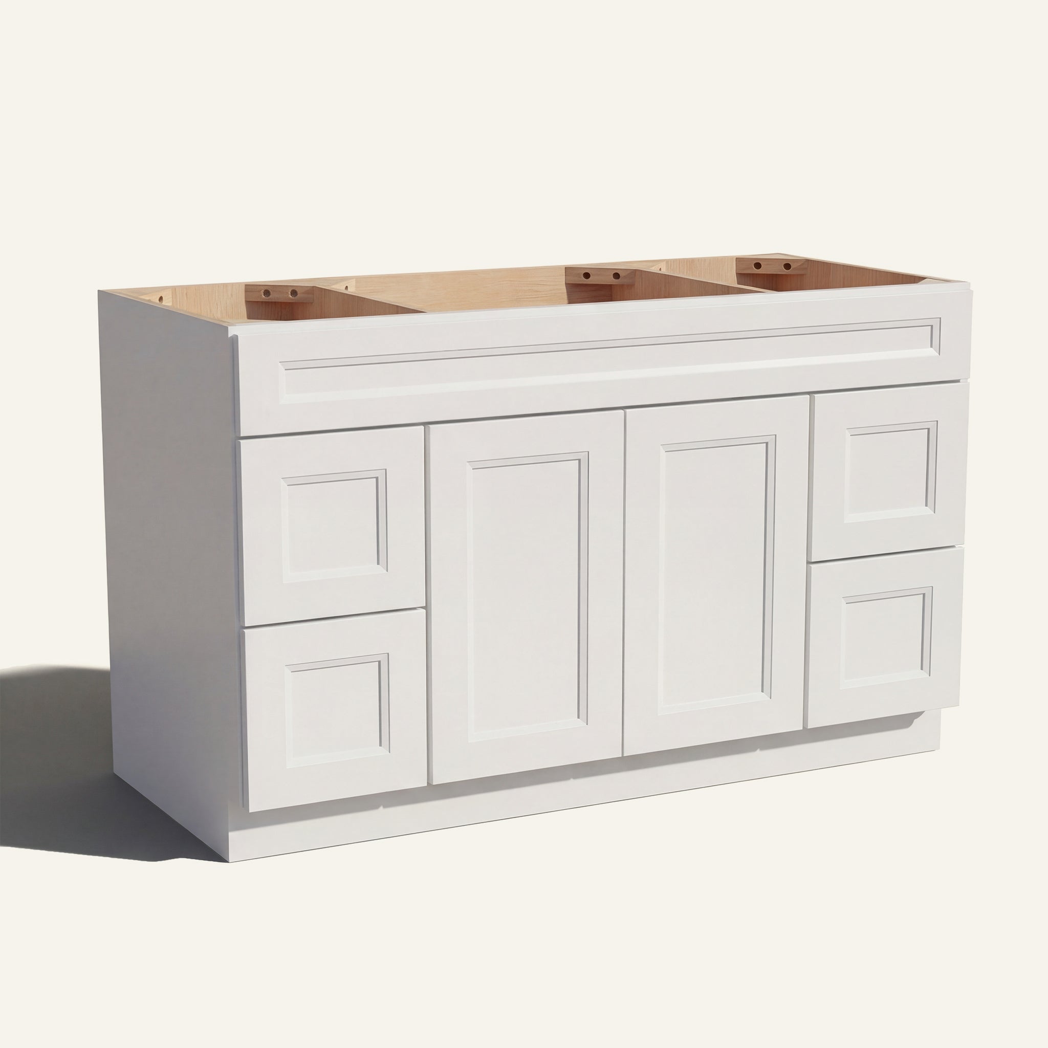 Angled view of a white Belmont beveled Shaker wide single sink vanity base with 2 doors, 4 drawers, and 1 false drawer front.