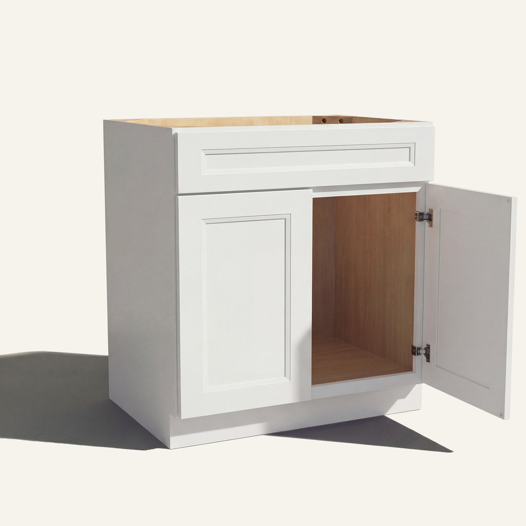 Angled view of white Belmont beveled Shaker single sink vanity, 1 false front, 2 doors with right one open to a wood interior.