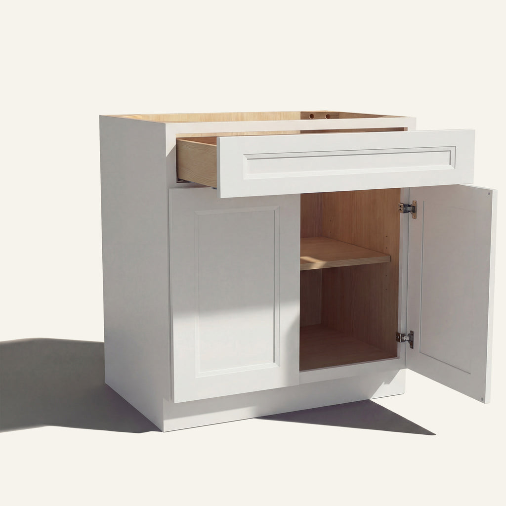 Angle view of a white Belmont beveled shaker base cabinet with 2 doors and 1 open drawer. Right door is open, showing a shelf.