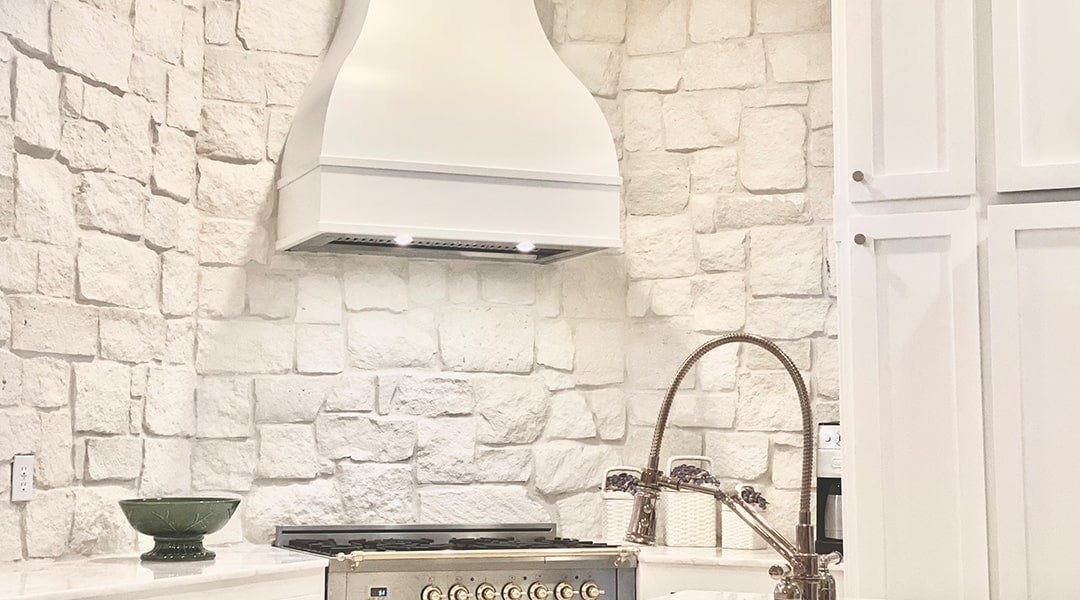 Kitchen with a bell style wood range hood