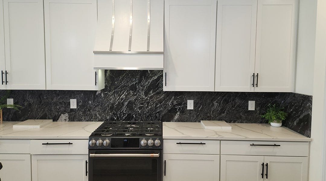 Kitchen with a sloped style wood range hood
