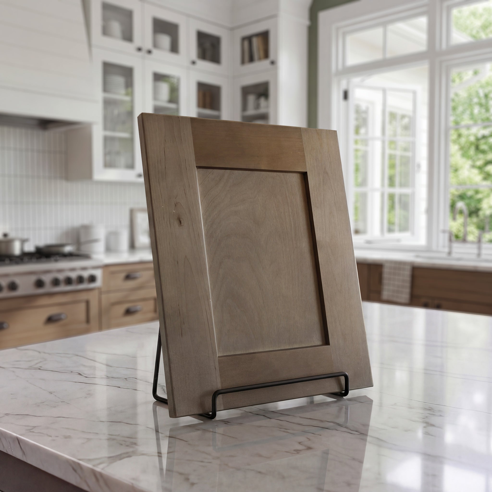 Angled Seaport shaker cabinet door sample in medium brown stained birch wood on a counter against a kitchen backdrop.