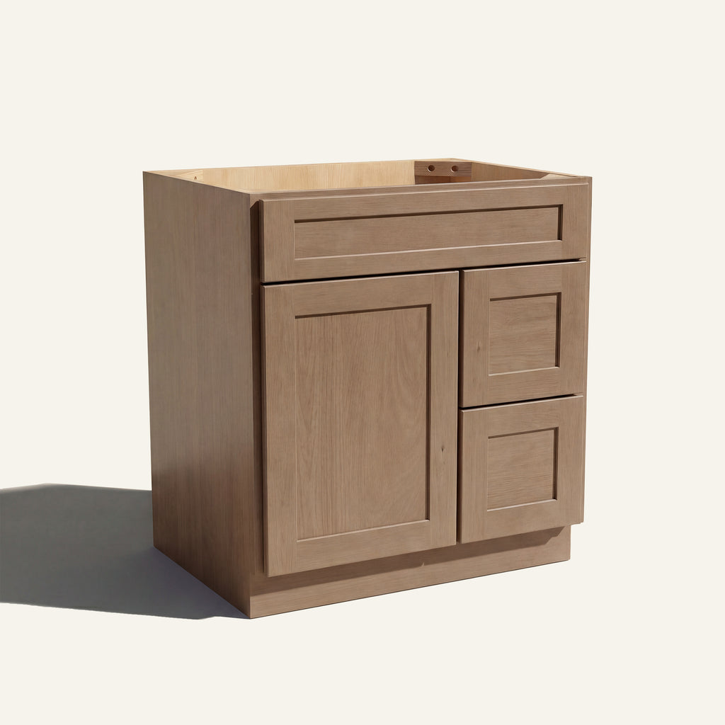 Angled view of a driftwood Seaport shaker single sink vanity with a left-side door and two right-side drawers.
