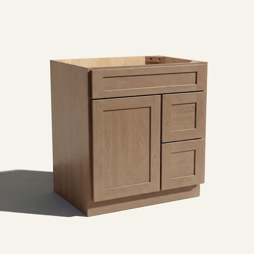 Angled view of a driftwood Seaport shaker single sink vanity with a left-side door and two right-side drawers.