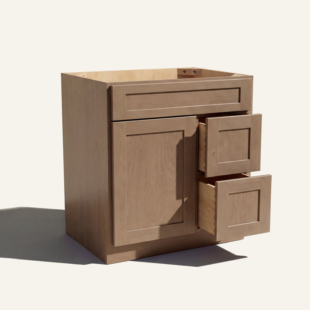 Warm bathroom scene of a driftwood Seaport shaker single sink vanity with 1 door, 2 drawers right, and 1 false front.