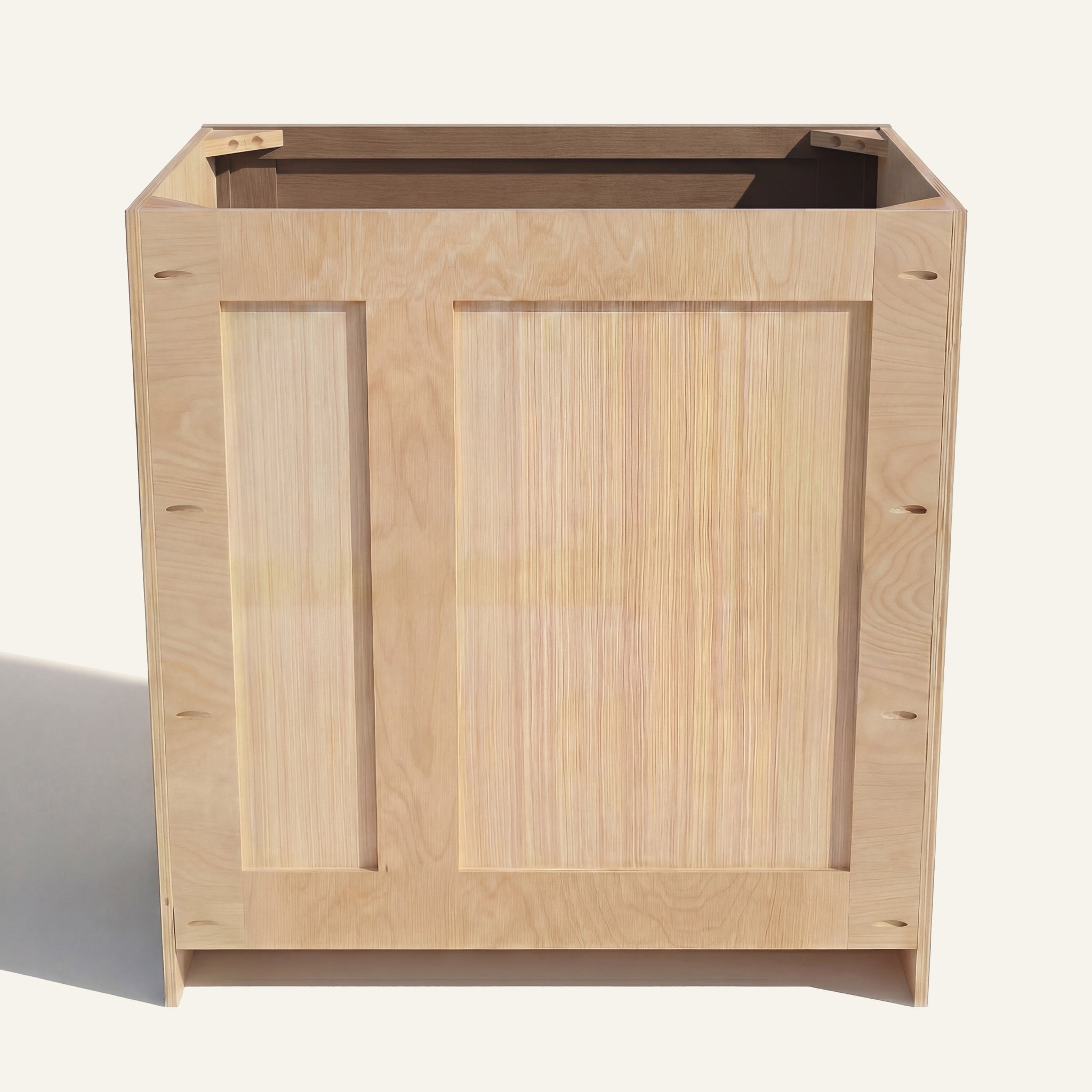 Rear view of a driftwood Seaport vanity with offset plumbing supports, pocket screw holes, and builder grade plywood construction.