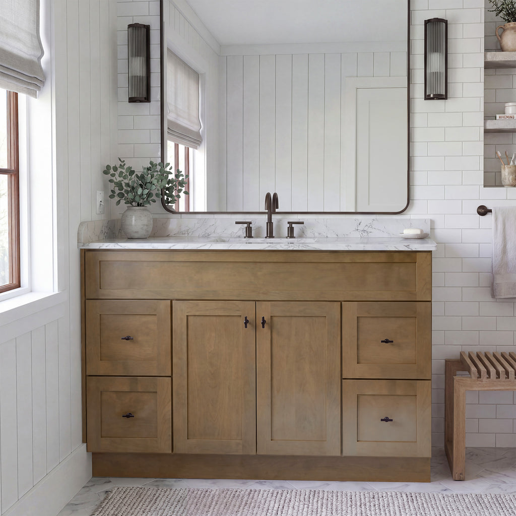 Front view of a driftwood Seaport shaker vanity with 2 doors, 4 drawers, and 1 false drawer front in a warm traditional bathroom.