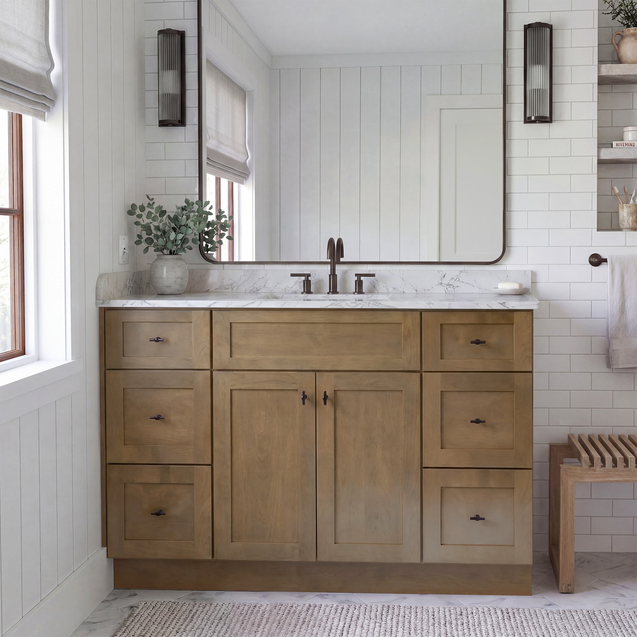 Front view of a driftwood Seaport shaker vanity with 2 doors, 6 drawers, and 1 false drawer front in a warm traditional bathroom.