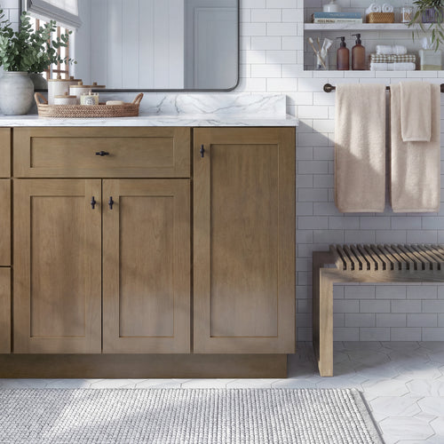 Front view of a driftwood Seaport traditional vanity base cabinet with 3 doors and 1 drawer in a styled bathroom.