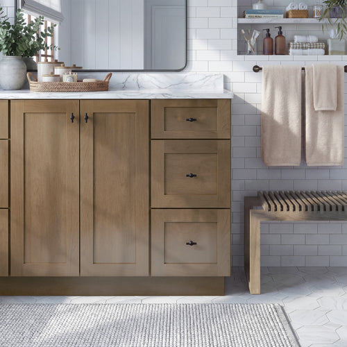 Front view of a driftwood Seaport traditional vanity base cabinet with 2 full-height doors and 3 drawers in a styled bathroom.