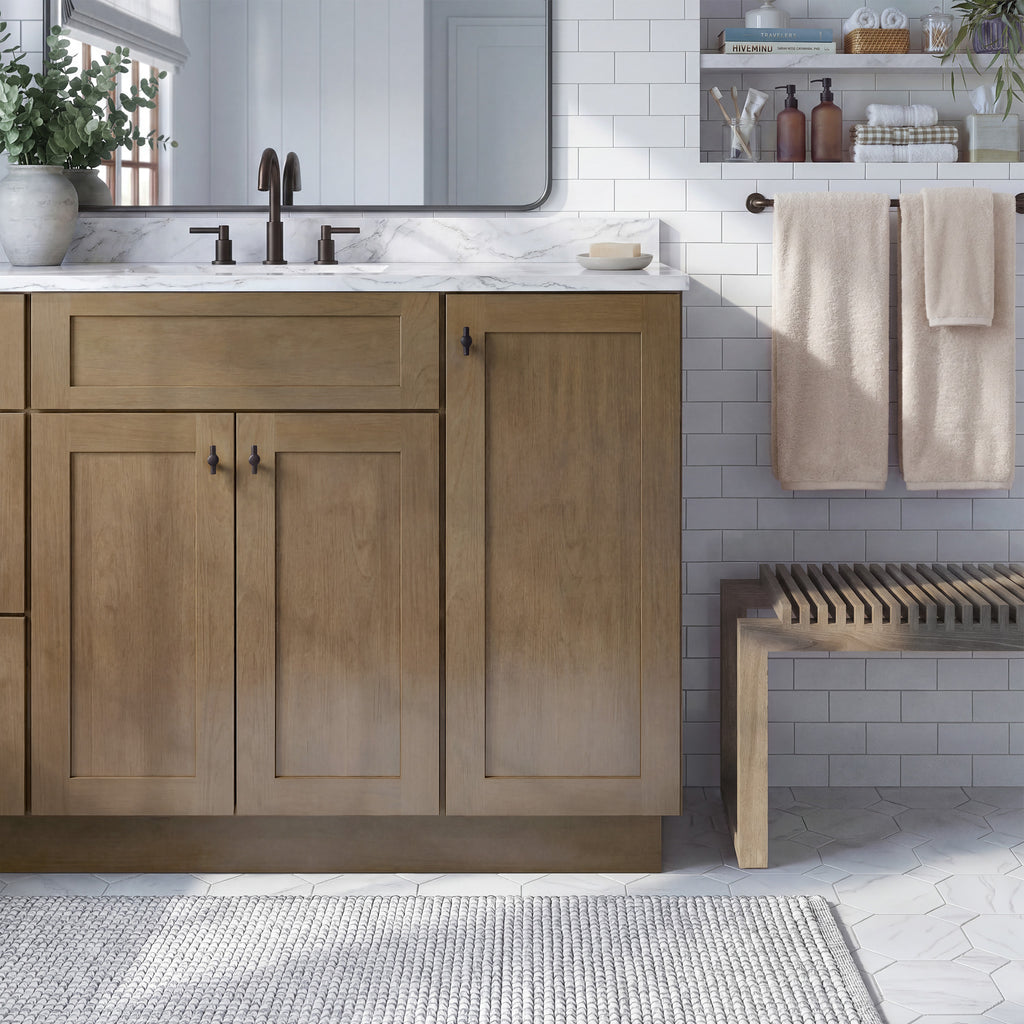 Front view of a driftwood Seaport traditional vanity base cabinet with 3-doors and 1 false drawer in a styled bathroom.
