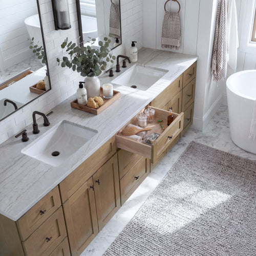 Top-down angled view of a driftwood Seaport shaker vanity with an open drawer, lived-in feel, and Mont Blanc quartzite counter.